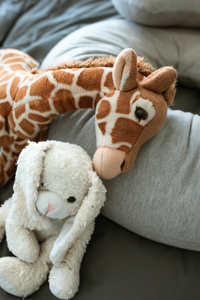 Services Soft giraffe and bunny toys on a cozy blanket, perfect for childhood comfort.
