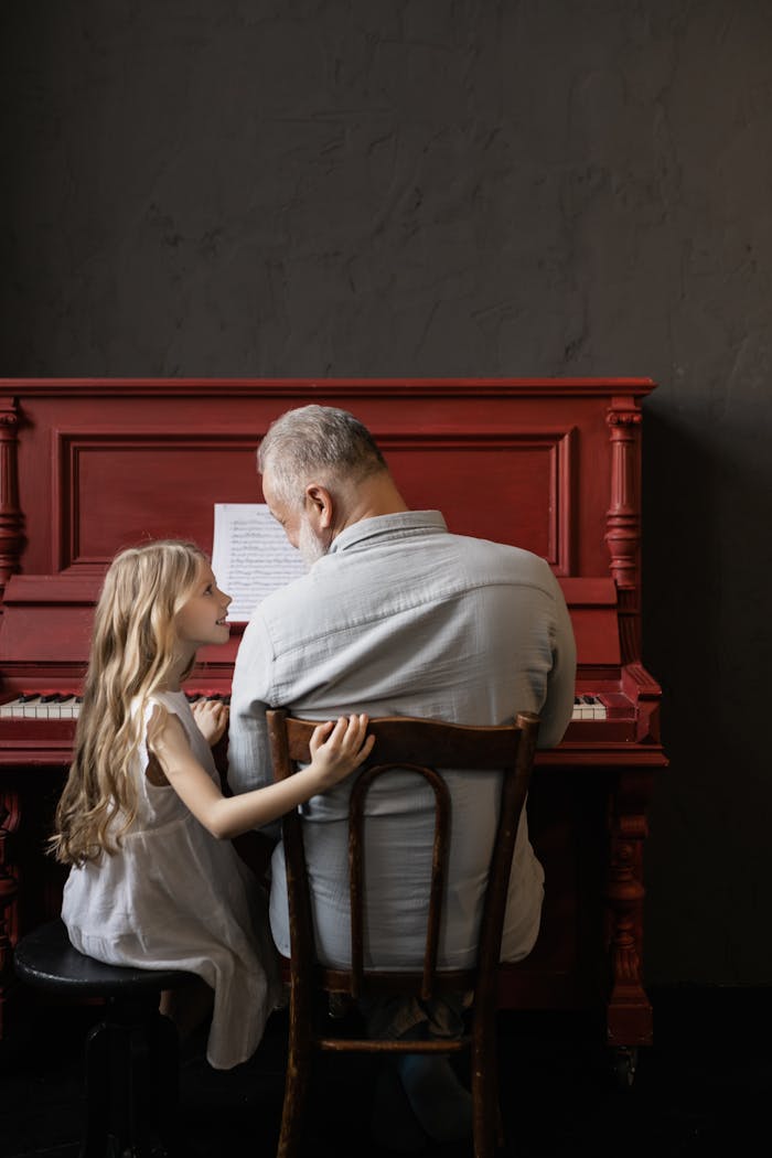 Services A young girl and her grandfather enjoying a piano session, symbolizing family bonding and music learning.