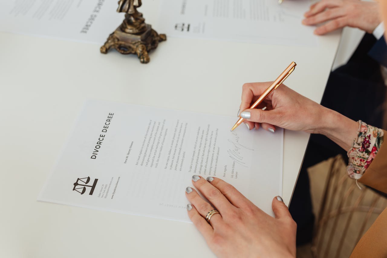 The Art of Drawing Readers In: Your attractive post title goes here Close-up of hands signing a divorce decree document on a desk, showcasing legal process.